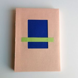 cuaderno color salmón con ventana azul noche y cinta verde claro